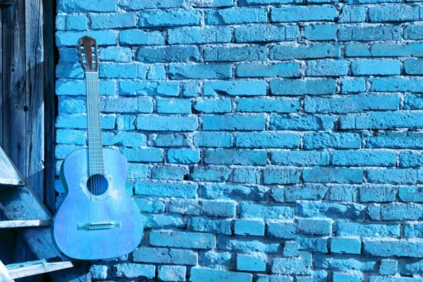Blue Guitar on Brick Wall